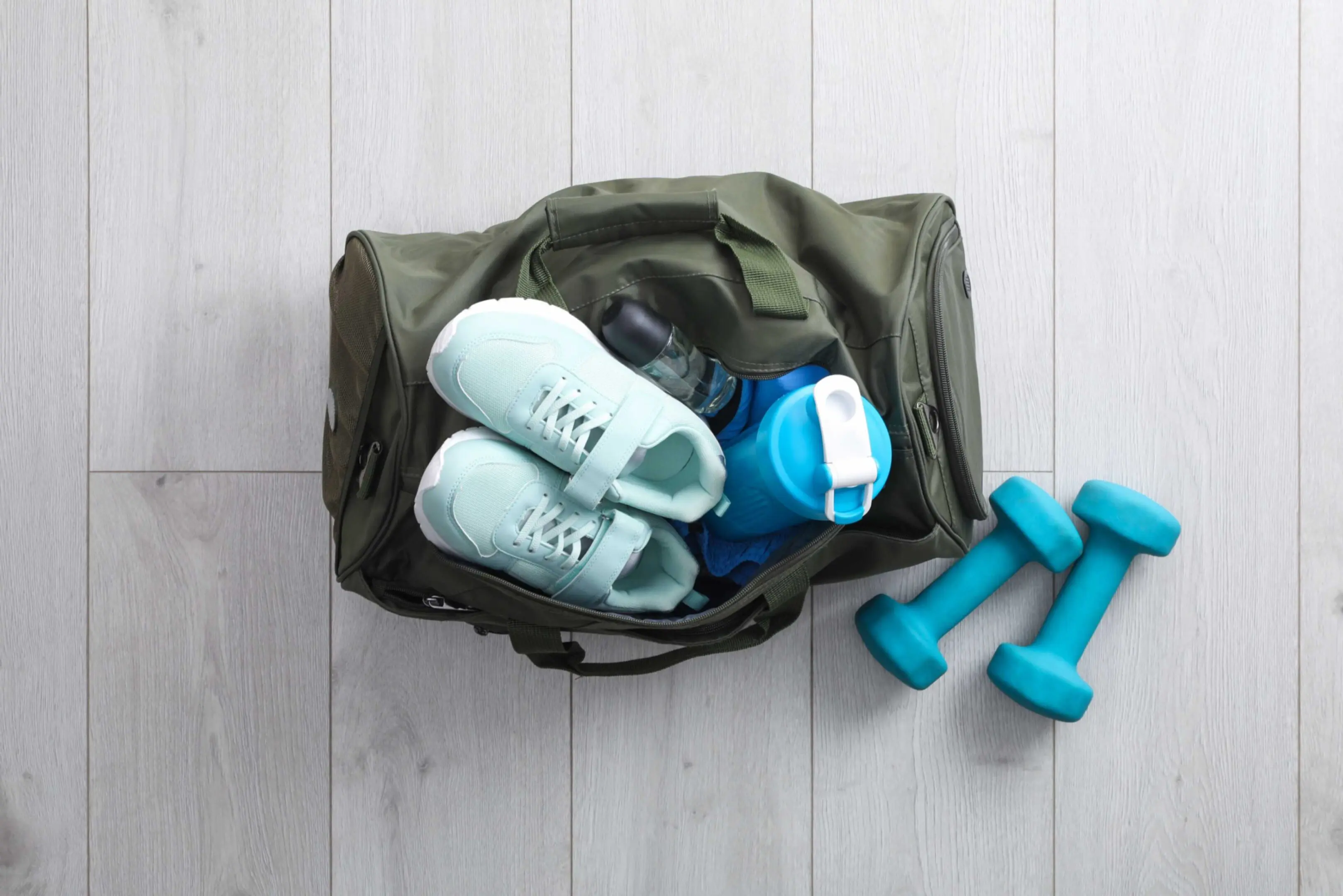 Gym bag with sneakers and dumbbells.