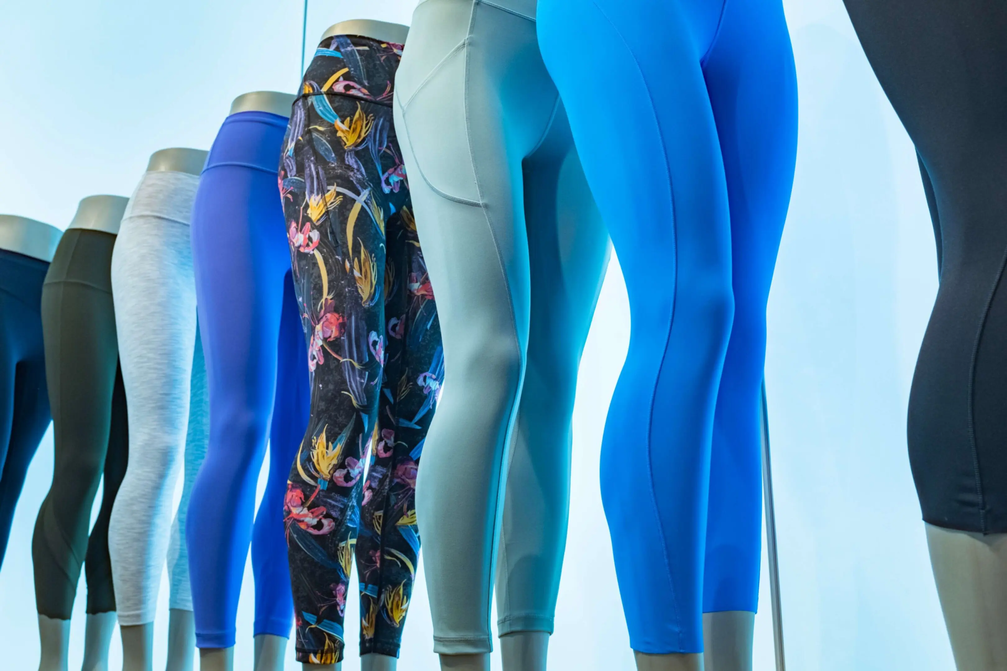 Mannequins displaying colorful leggings in store.