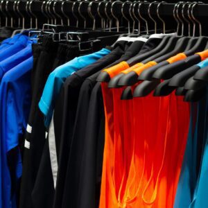 Colorful sports shirts hanging on display rack.