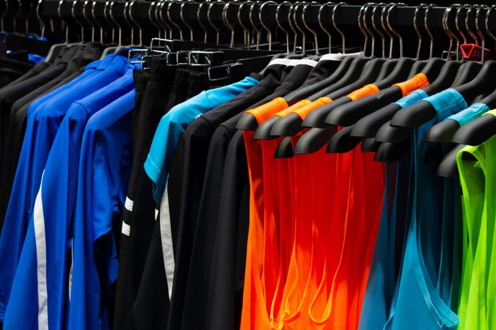 Colorful sports shirts hanging on display rack.