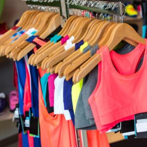 Colorful sports bras and tops on hangers.