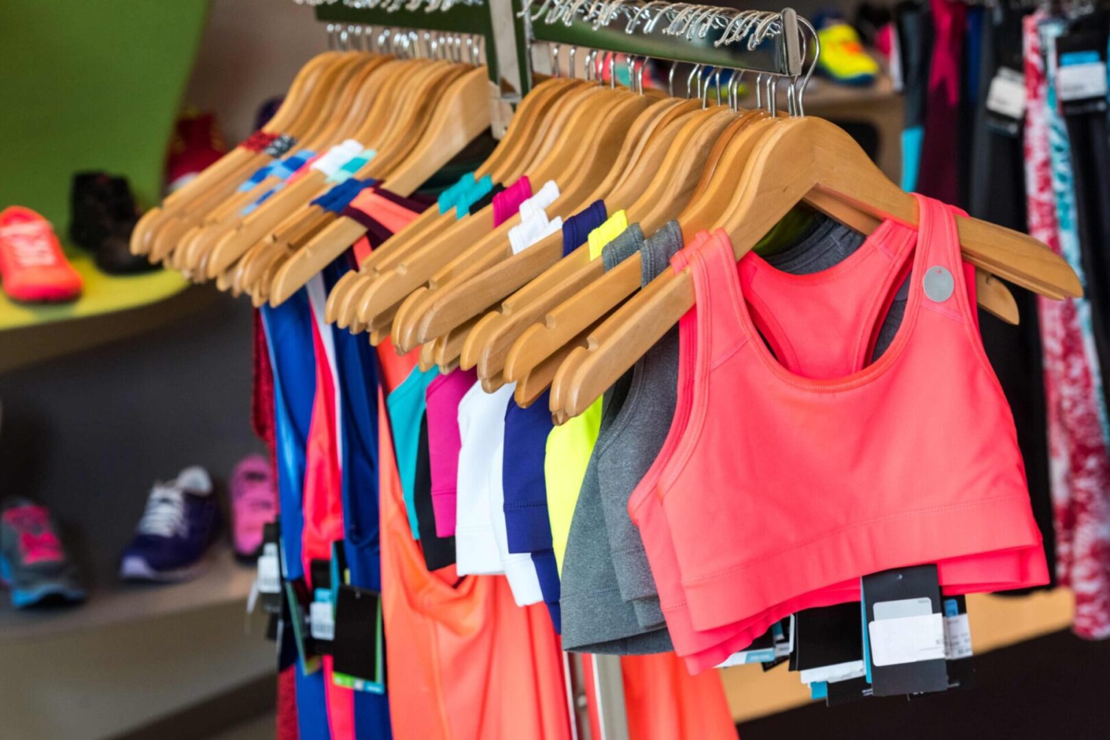 Colorful sports bras and tops on hangers.
